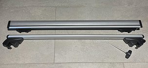 Zwei Grundträger für die Dachreling in silber liegen nebeneinander auf Fliesenboden