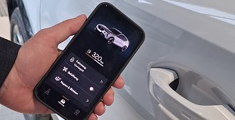 Eine Hand hält ein Smartphone vor einem Auto. Auf dem Smartphone sind Inhalte der Connect App abgebildet, zum Beispiel aktuelle Tankfüllung.(Ratio Mobil)