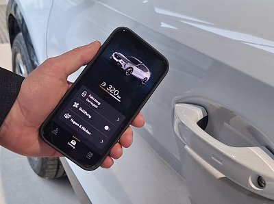 Smartphone mit Connect App vor einem Auto (Ratio Mobil)